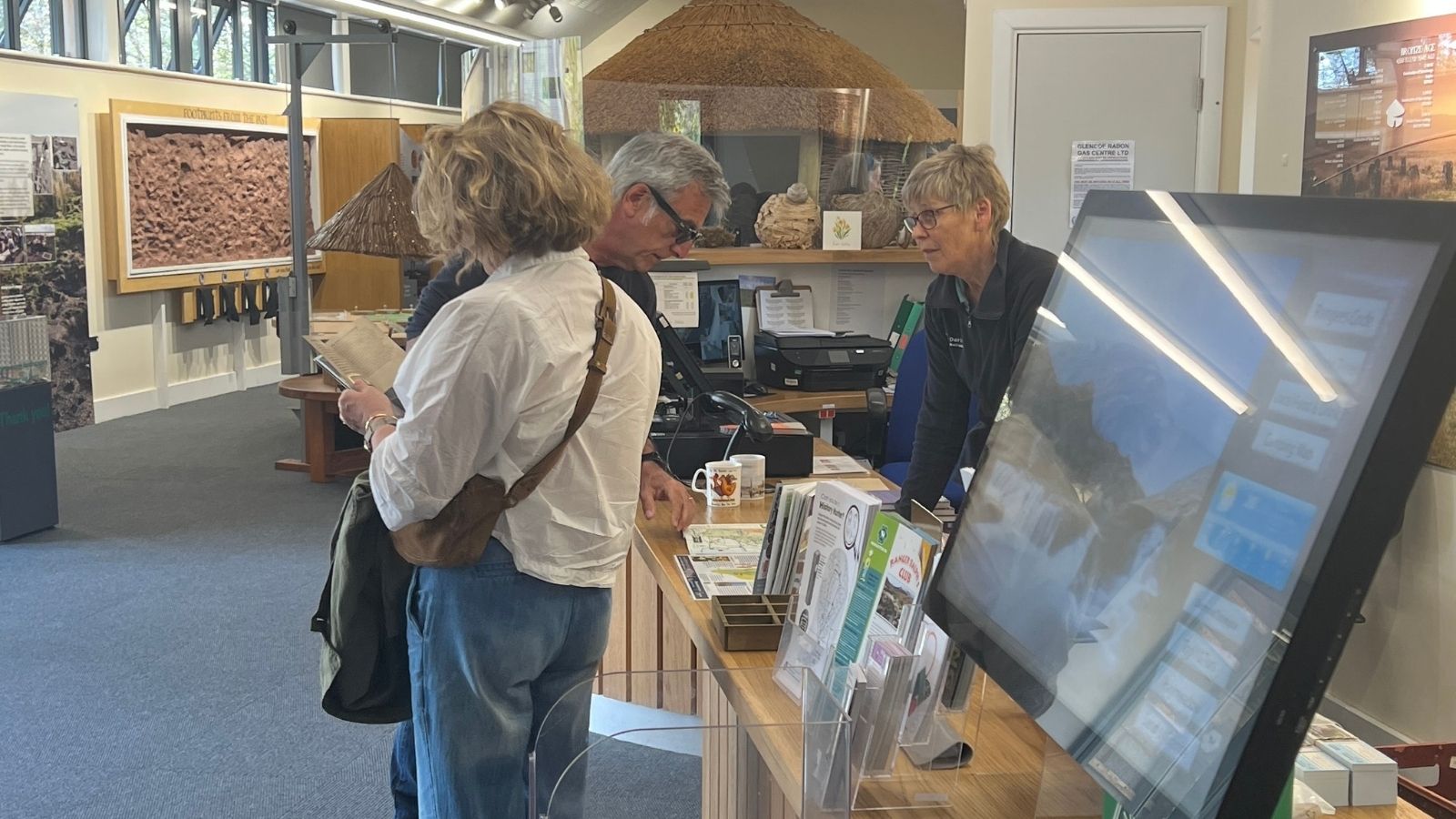 People stand by the counter on the left with displays in the background.