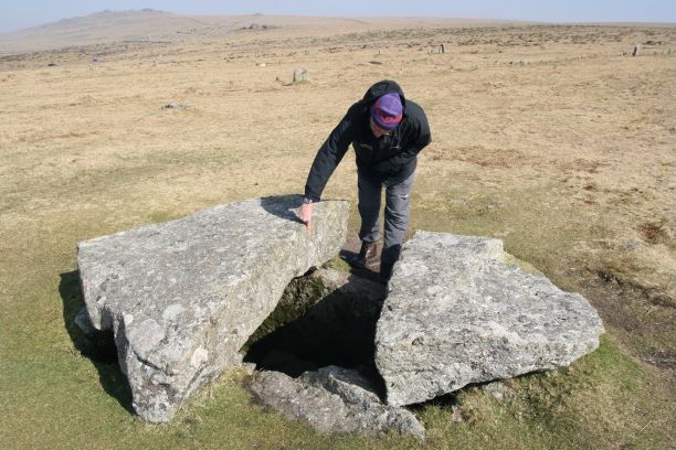 DNPA staff pointing at a broken capstone on a cist at Merrivale. DNPA-Cist-at-Merrivale-comp