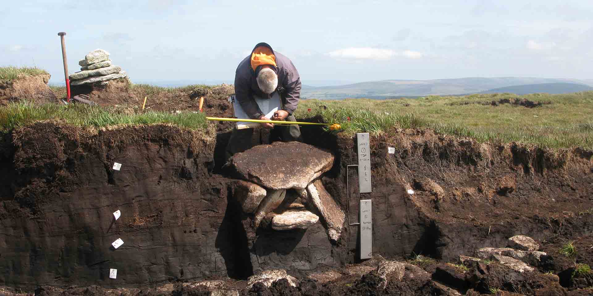 Archaeologist measuring dug-out cist at Whitehorse Hill