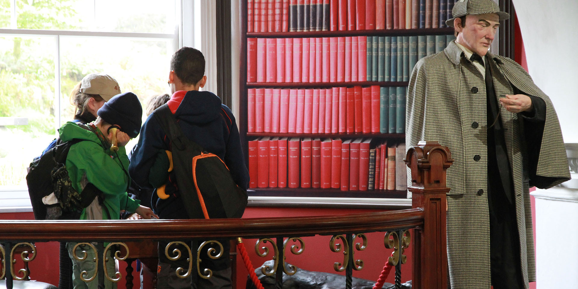 School children engaging with prop telephone next to Sherlock Holmes model