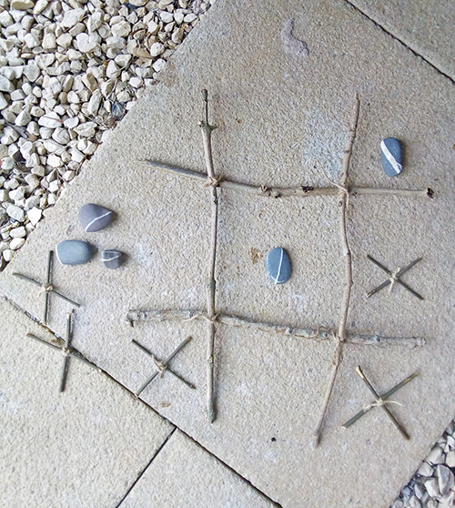 Noughts and crosses game made from twigs and stones
