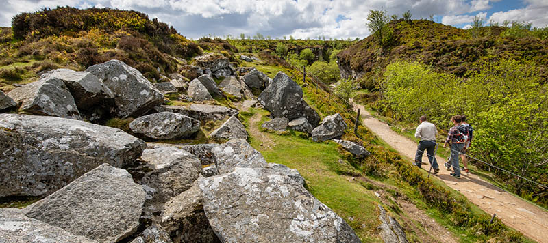 Three people walking along track to quarry