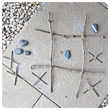 Noughts and Crosses game made out of twigs and stones