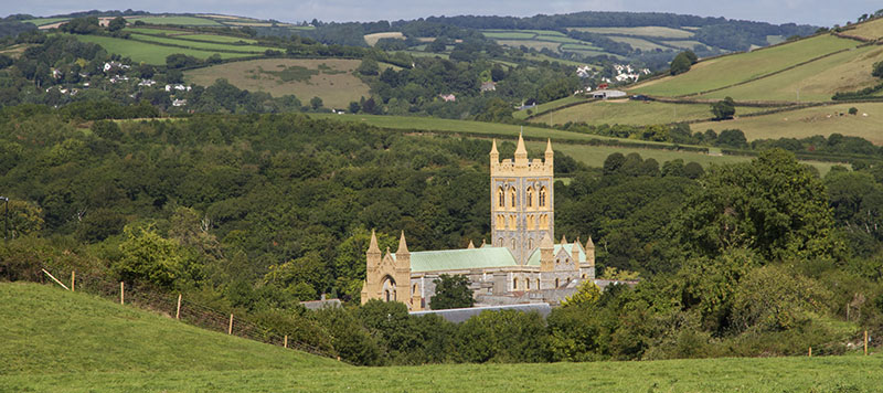 Large old abbey sticking out of rolling green hills