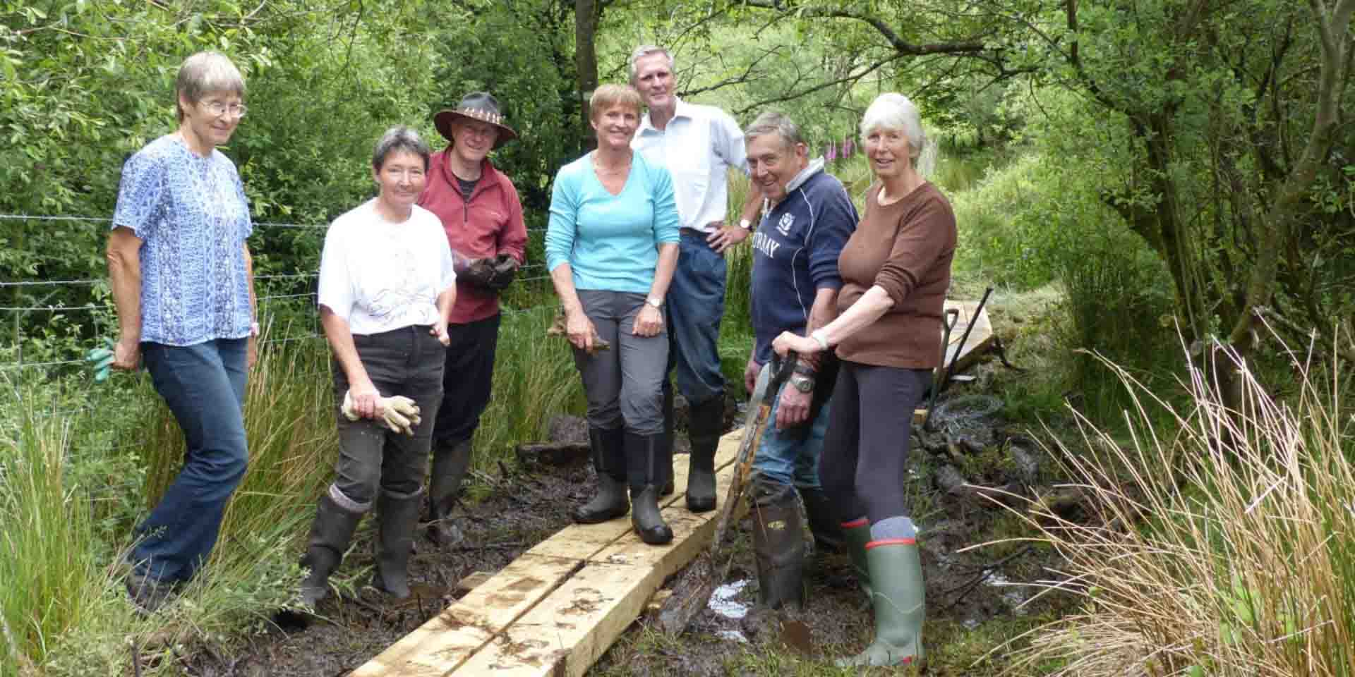 Volunteers building a boardwalk over the marshy ground