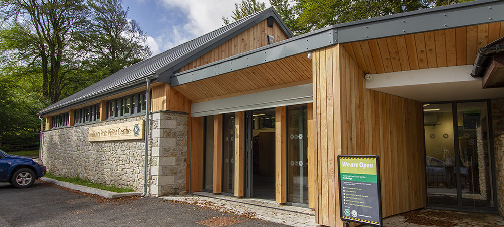 Granite building with wooden sign that says 'National Park Visitor Centre'