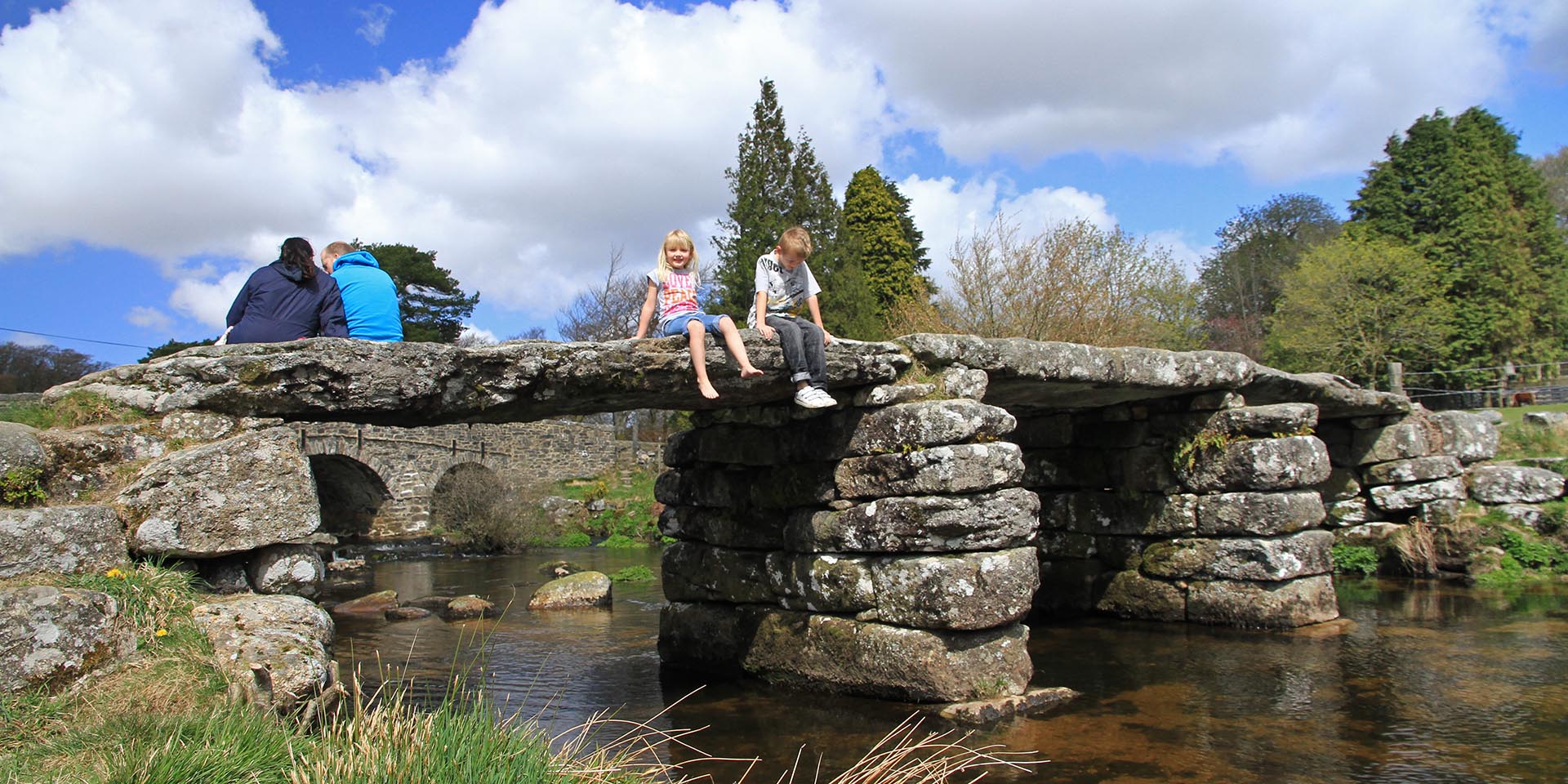 Children sat on clapper bridge at Postbridge