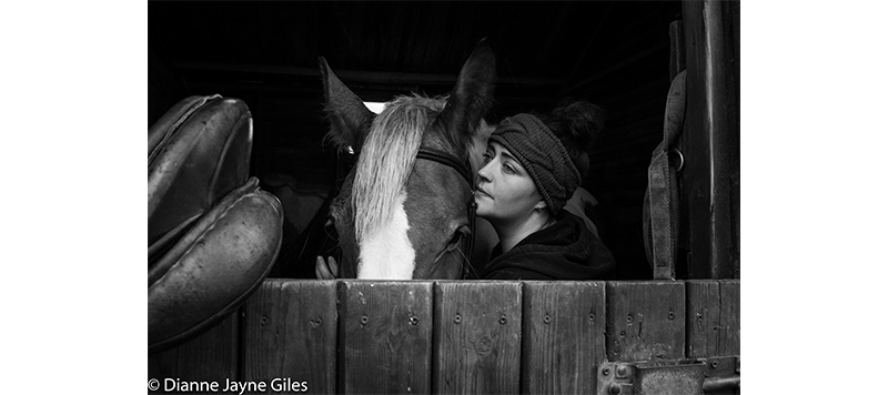 Girl in stable with her horse