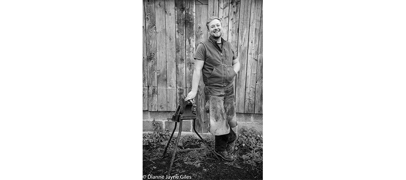 Farrier Ben standing in front of a barn smiling