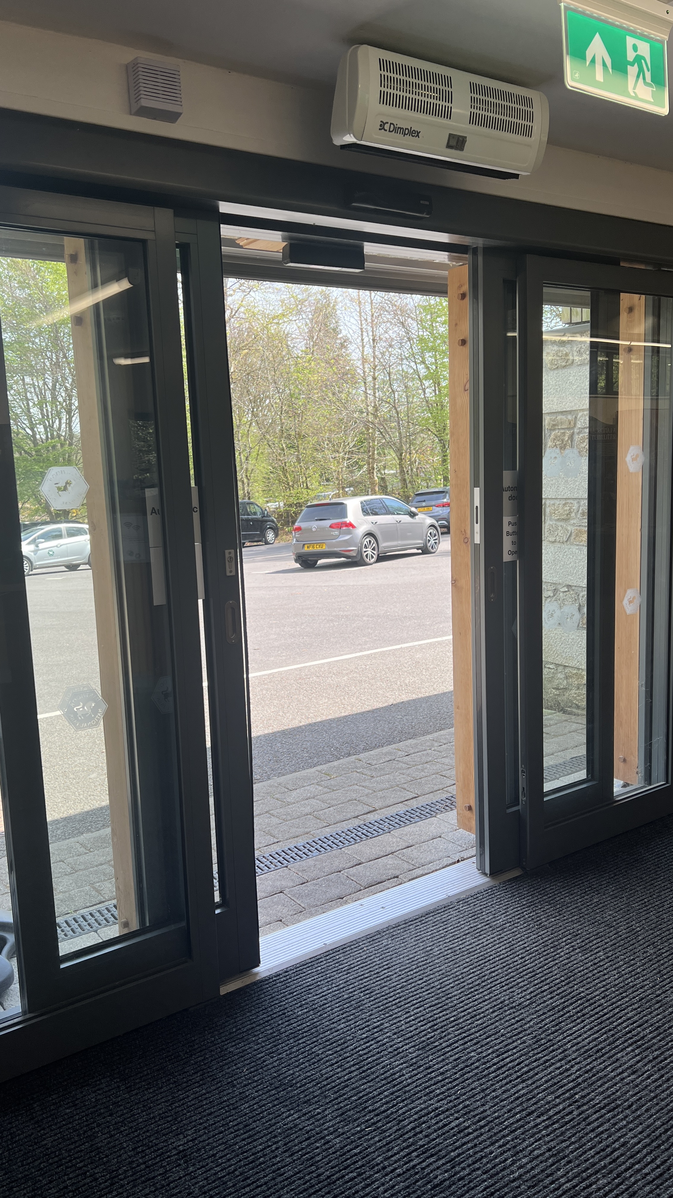 Entrance to the Postbridge Visitor centr from inside, looking out to the car parkl through open doors 
