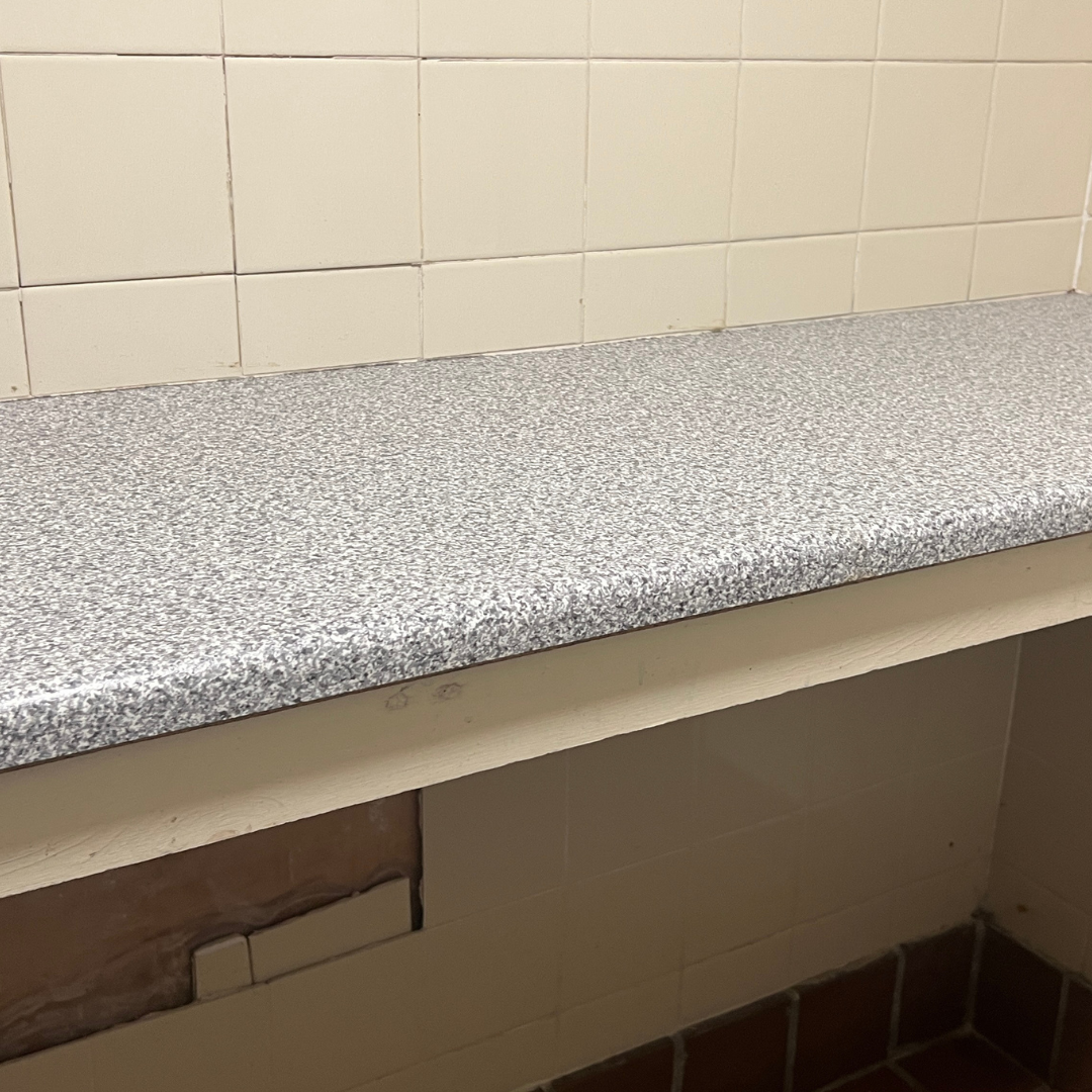 Long worktop with a bar across. Baby changing facilities