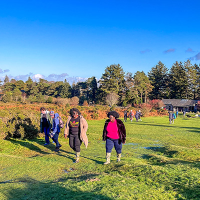 Group of people walking up towards Haytor with the Visitor Centre in the background